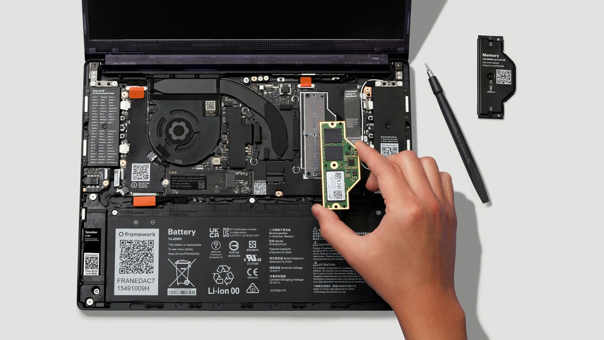 Nyitott Framework Laptop 13 Pro, kézben tartott LPCAMM2 memóriamodullal.