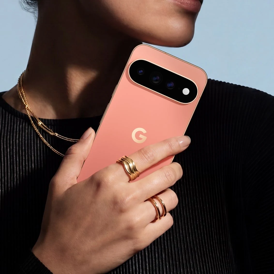 Pixel 11 Pro hátlapján töltővel, fa asztalon.