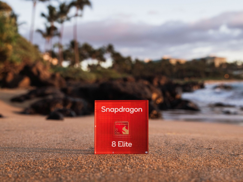 Piros Snapdragon 8 Elite chipdoboz homokos háttér előtt.