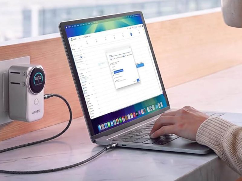 Anker Nano Travel Adapter with Display fali aljzatban, laptop töltése közben, bekapcsolt kijelzővel.