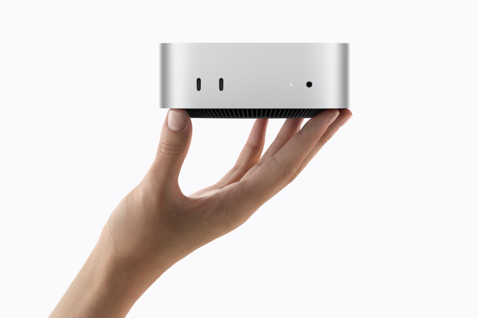 Kézben tartott ezüst Mac mini előlapi USB-C portokkal és fejhallgató-csatlakozóval.