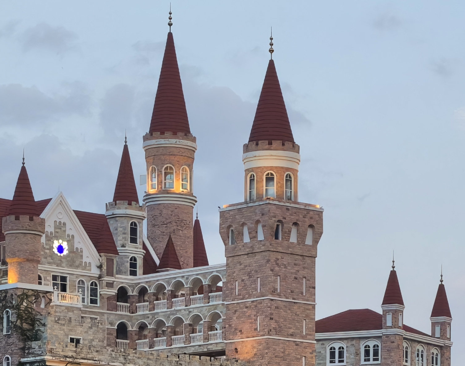 Alkonyati fényben fényképezett, vörös tornyú épület a Huawei Pura X View hivatalos kameramintáján.