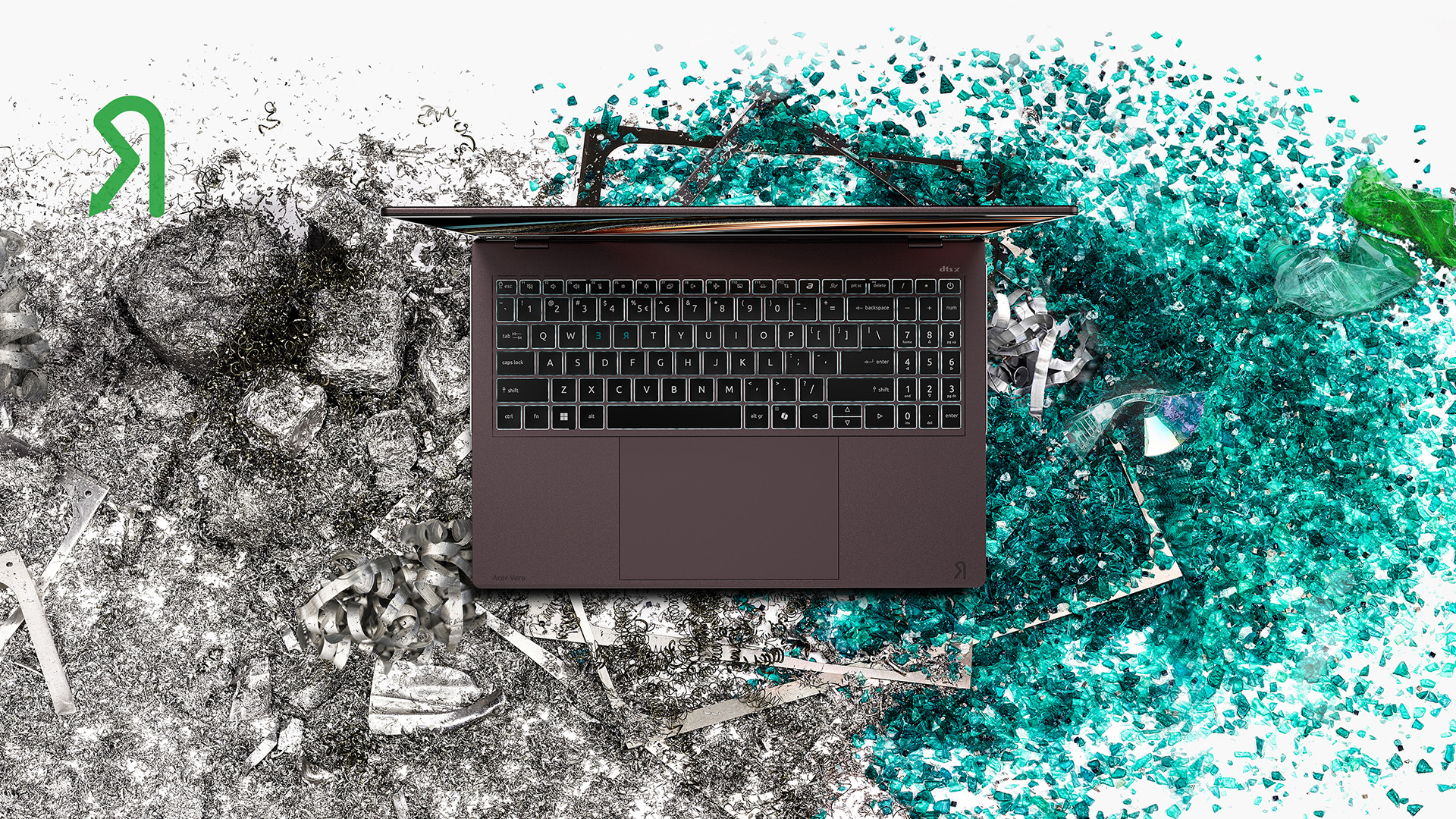 Acer Vero 16 felülnézetben, fémforgácsot és újrahasznosított műanyagot idéző háttér előtt.