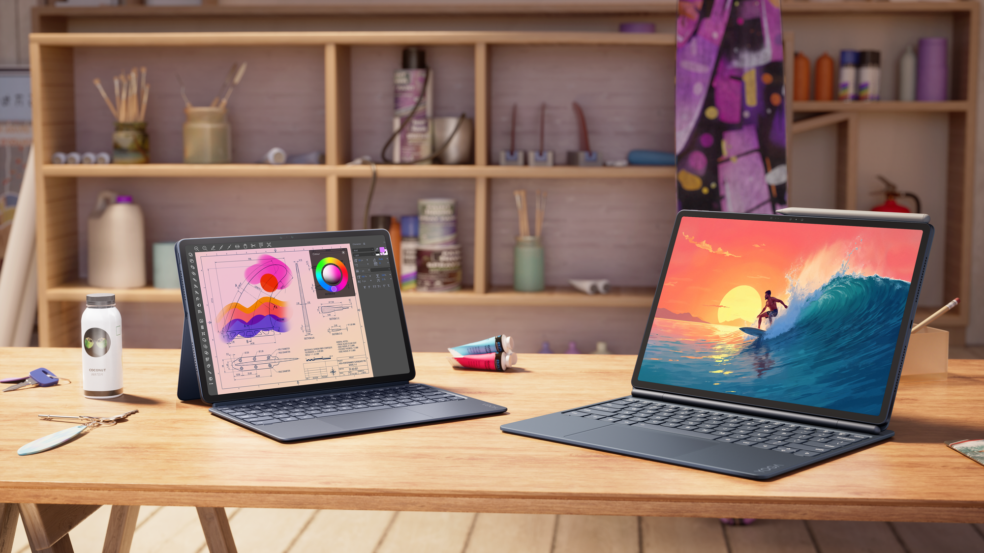 Két új Lenovo Yoga tablet eltérő méretben, billentyűzetes tokokkal egy műhelyasztalon.