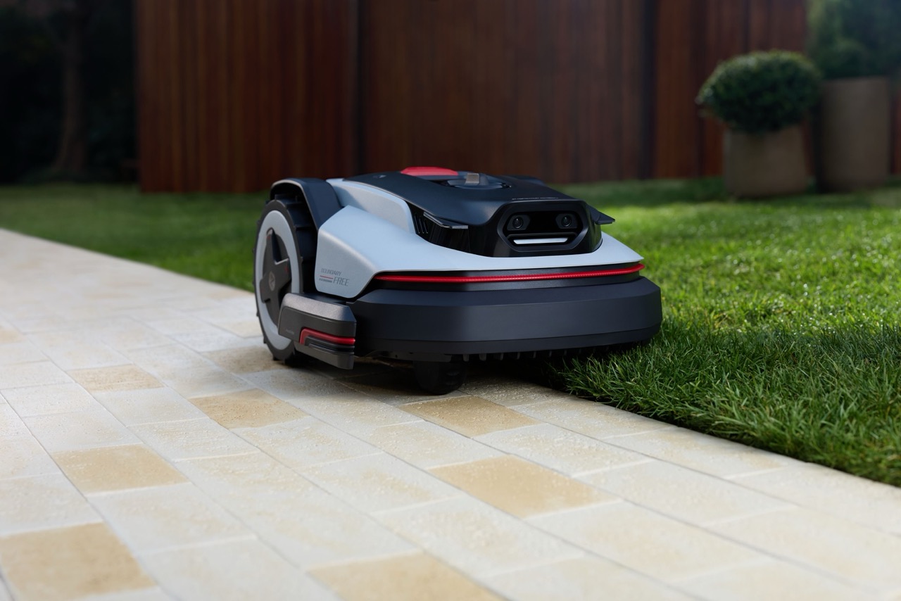 Roborock RockNeo Q2 LiDAR fűnyírórobot egy burkolt kerti út és a gyep szélén.