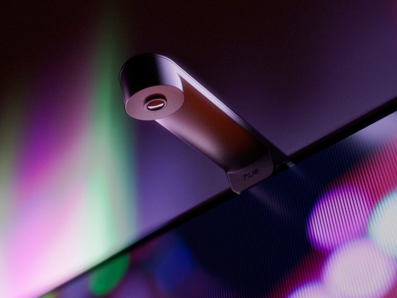 A Philips Hue Play Screen Sync kamerája a televízió felső élére rögzítve, színes háttérfénnyel.